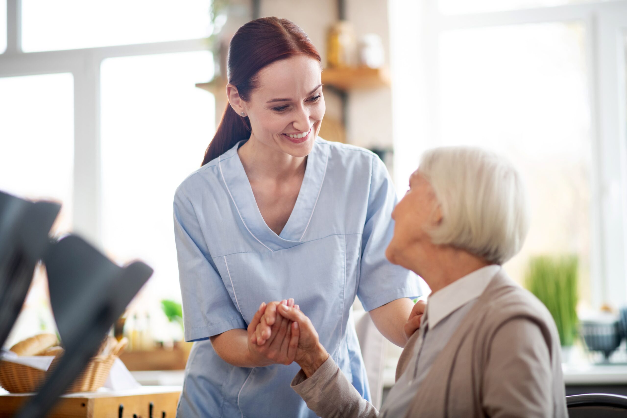caregiver providing assistance to elderly woman